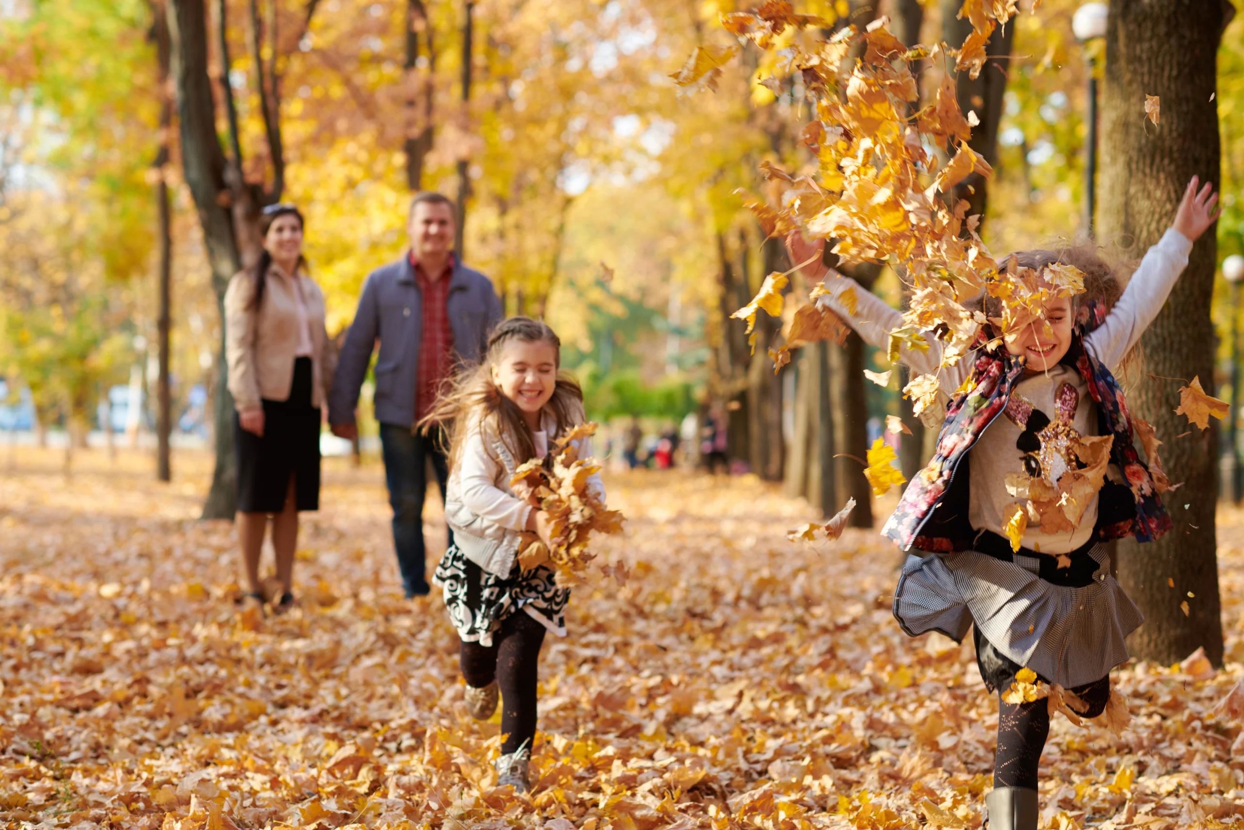 Family playing in fall leaves because mortgage rates have dropped